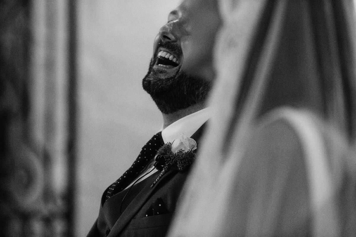 groom laughing at a wedding ceremony inside an old church in the south of france