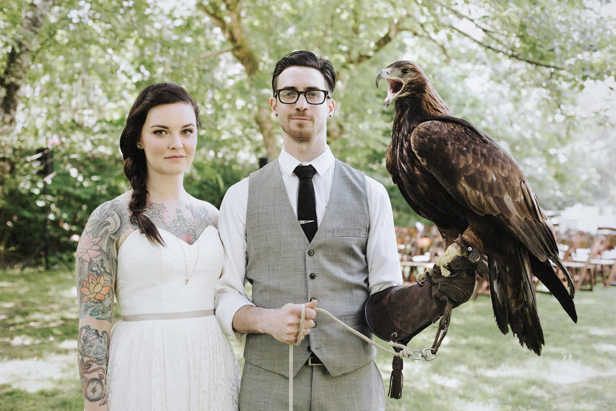 tattooed couple holding hawk