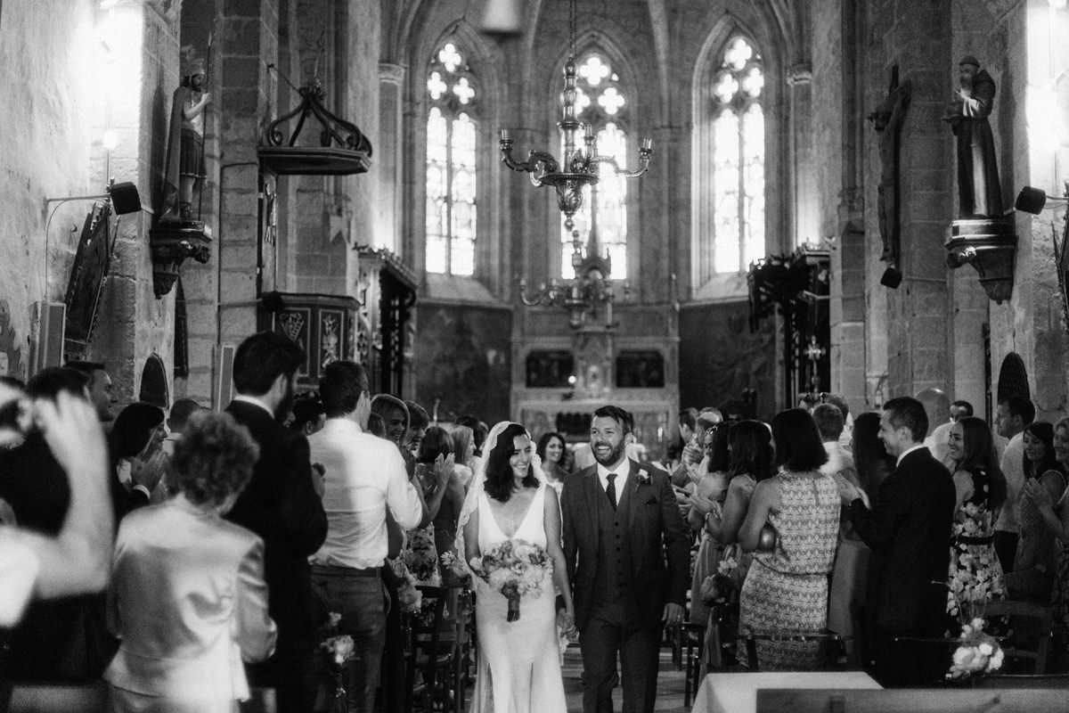 bride and groom walking down the aisle after their wedding ceremony inside an old church in the south of france