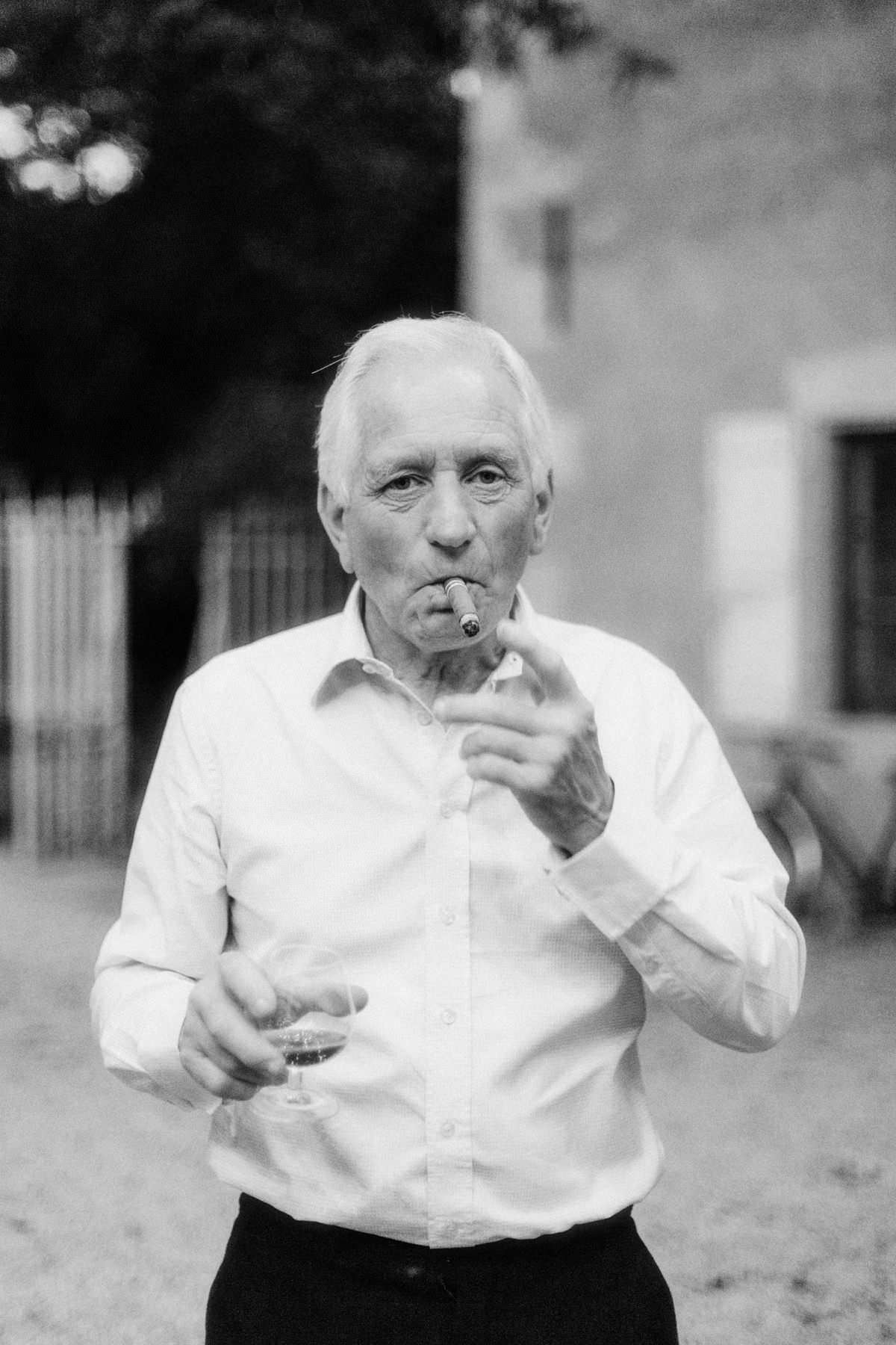 documentary style photo of a wedding guest smoking a cigar