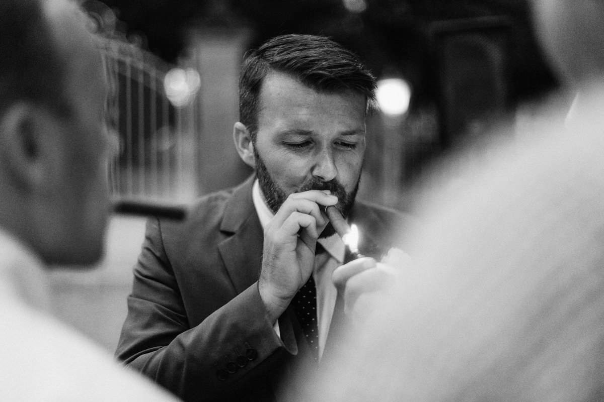 documentary style photo of a wedding guest smoking a cigar