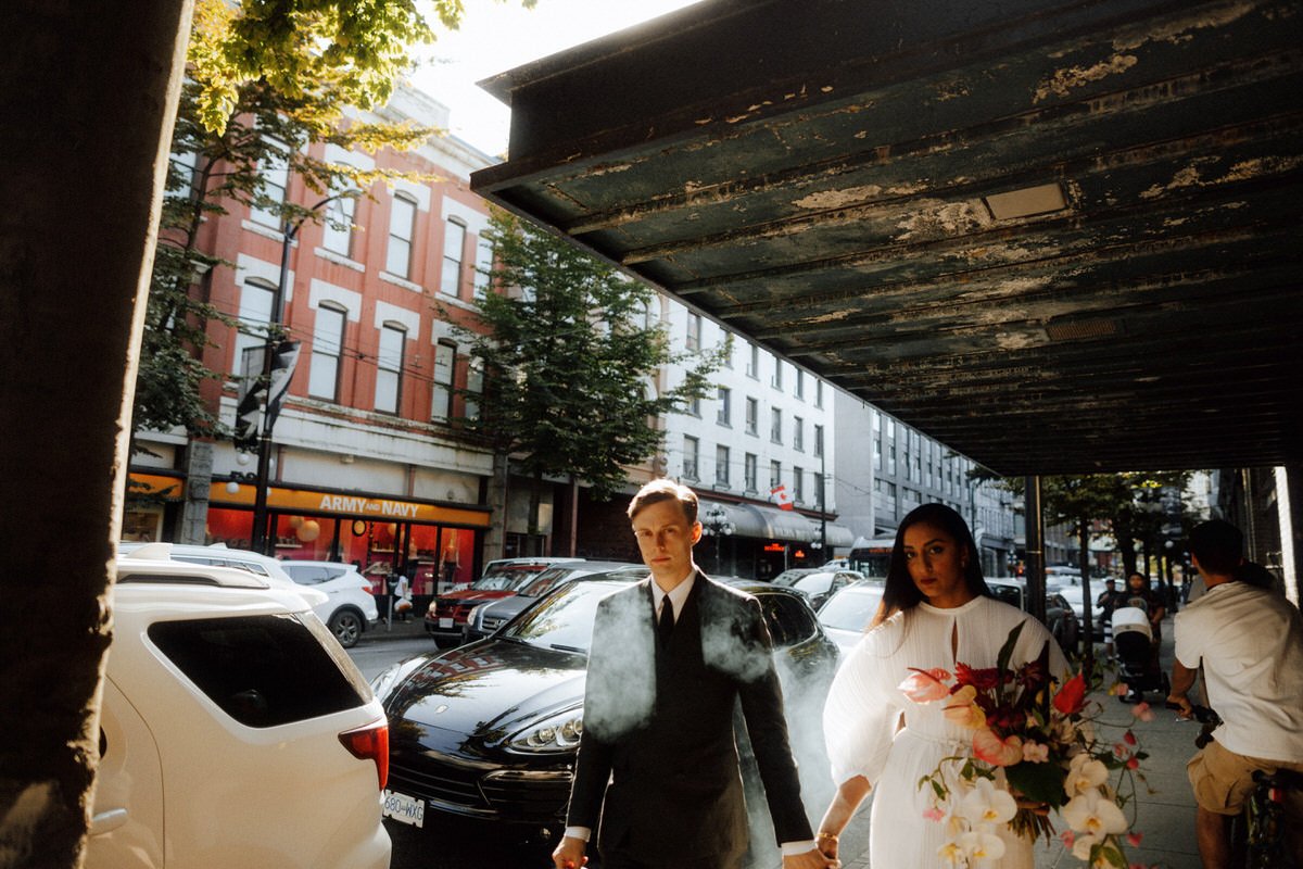 editorial style photo of bride and groom walking in downtown vancouver