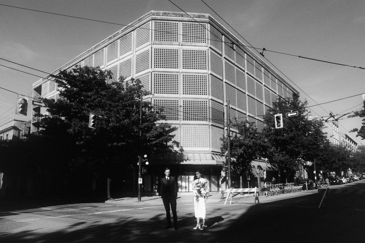 wedding couple standing outside brutalist architecture in downtown vancouver