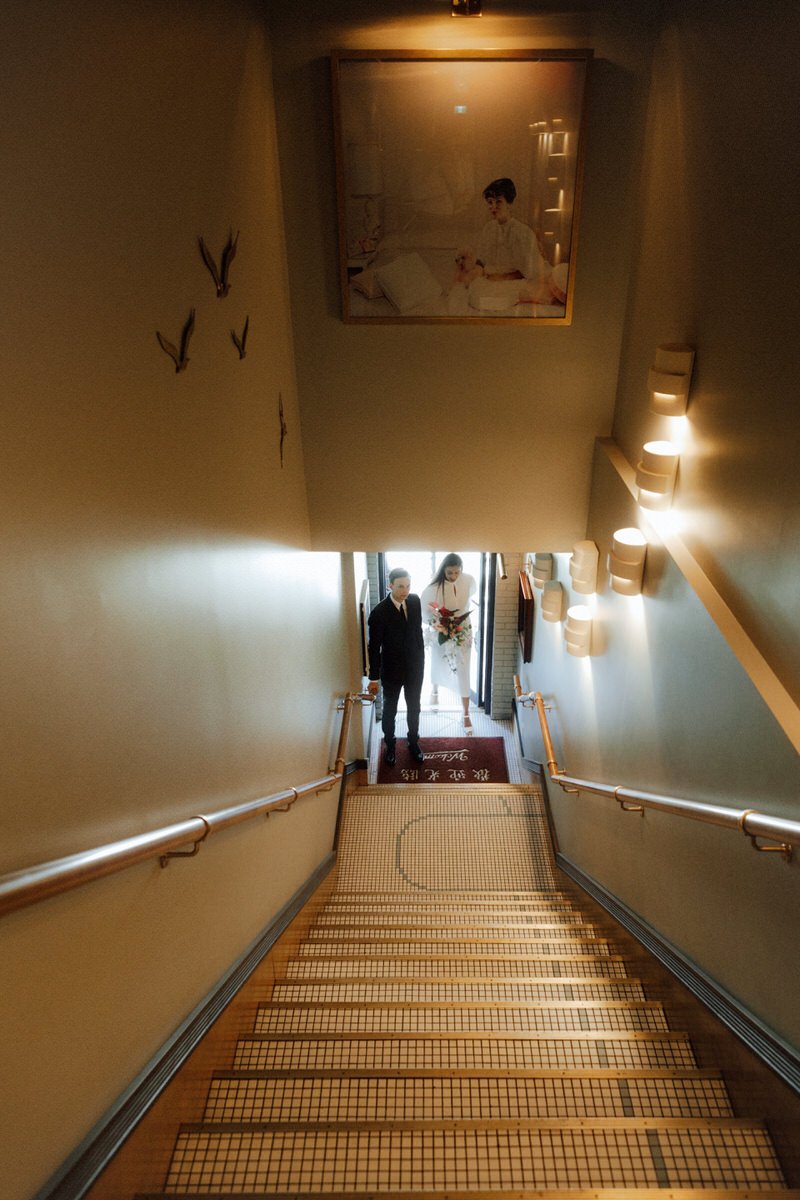 bride and groom walking up the staircase inside kissa tanto