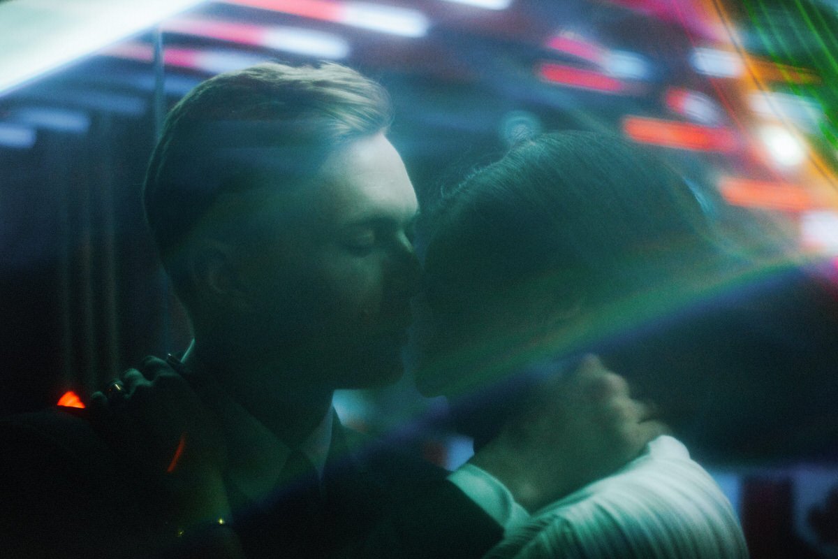 couple standing amongst coloured lights in a wong kar wai styled photograph