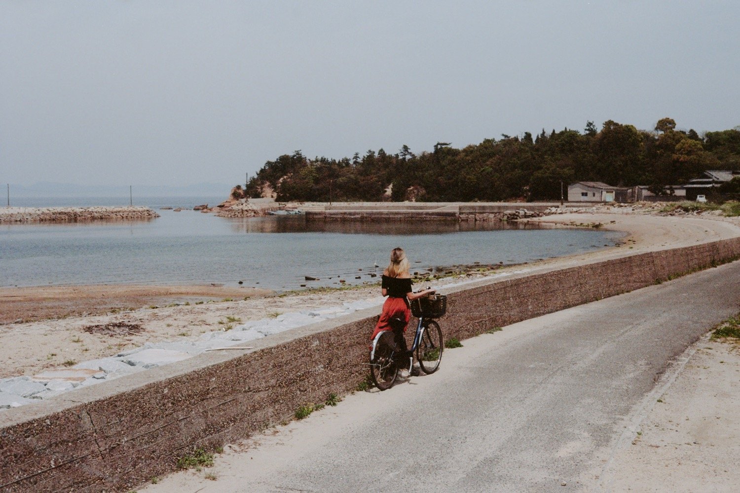 35mm photo of woman with bicycle exploring teshima island in japan