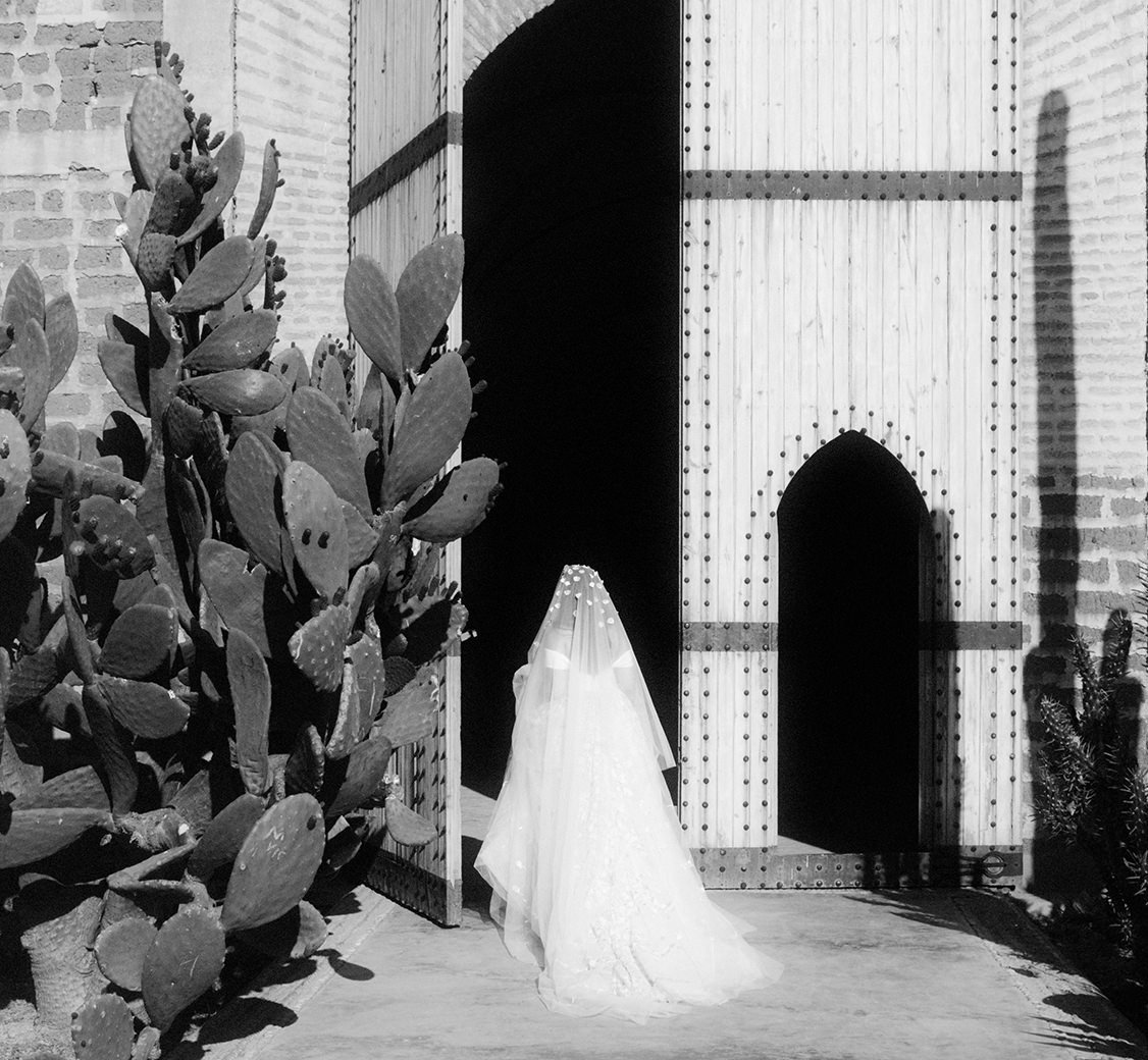 bride standing outside the tall doors to beldi country club in marrakech