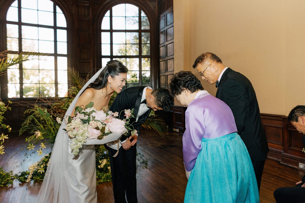 bride and groom respectfully bowing to Korean parents during their wedding ceremony at Ebell of LA