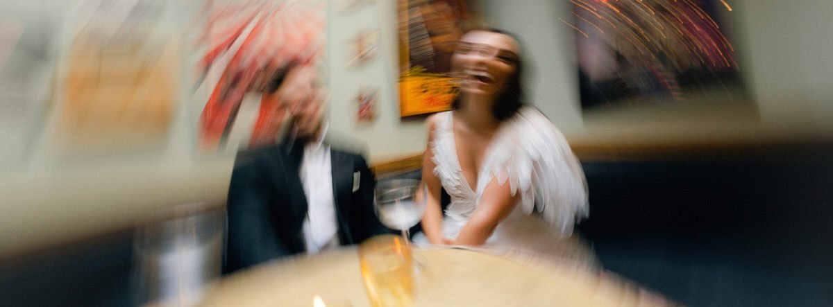 motion blur photo of bride and groom sitting in a restaurant booth in NYC
