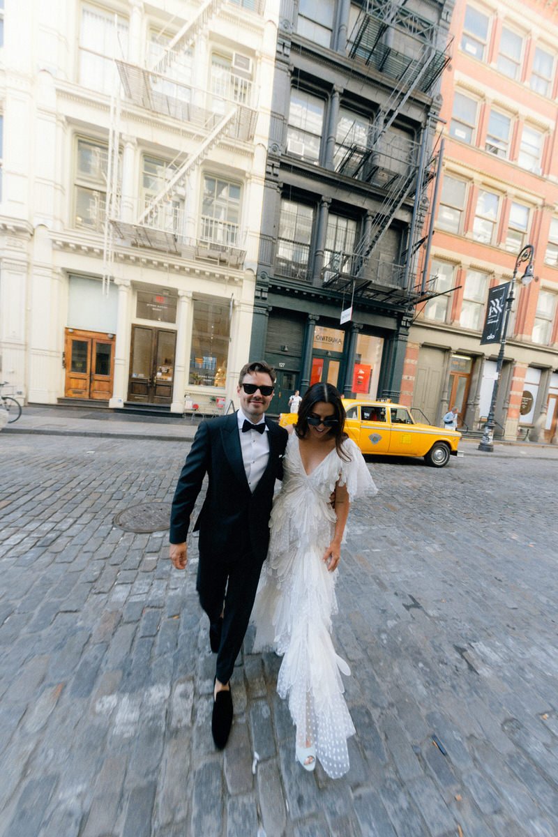 editorial style photo of bride and groom wearing sunglasses and walking around Manhattan