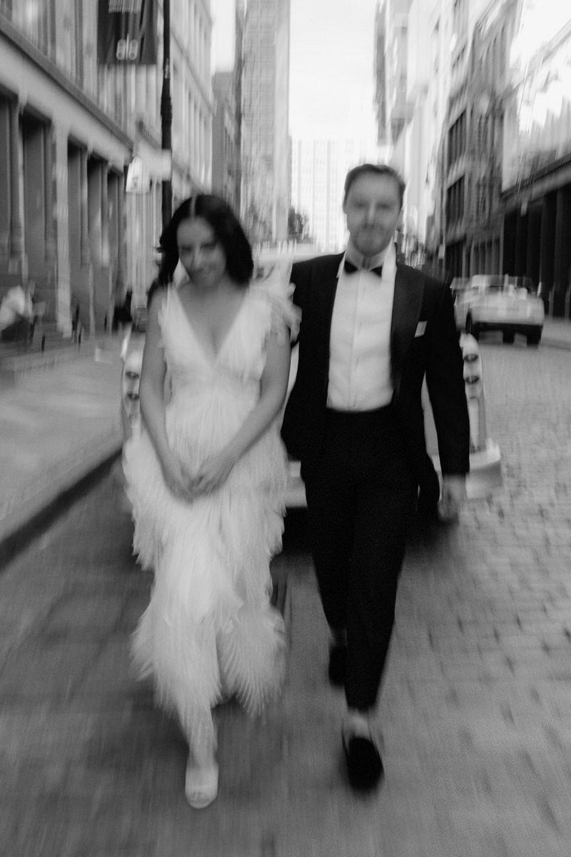 blurry editorial style photo of bride and groom walking the streets of Manhattan