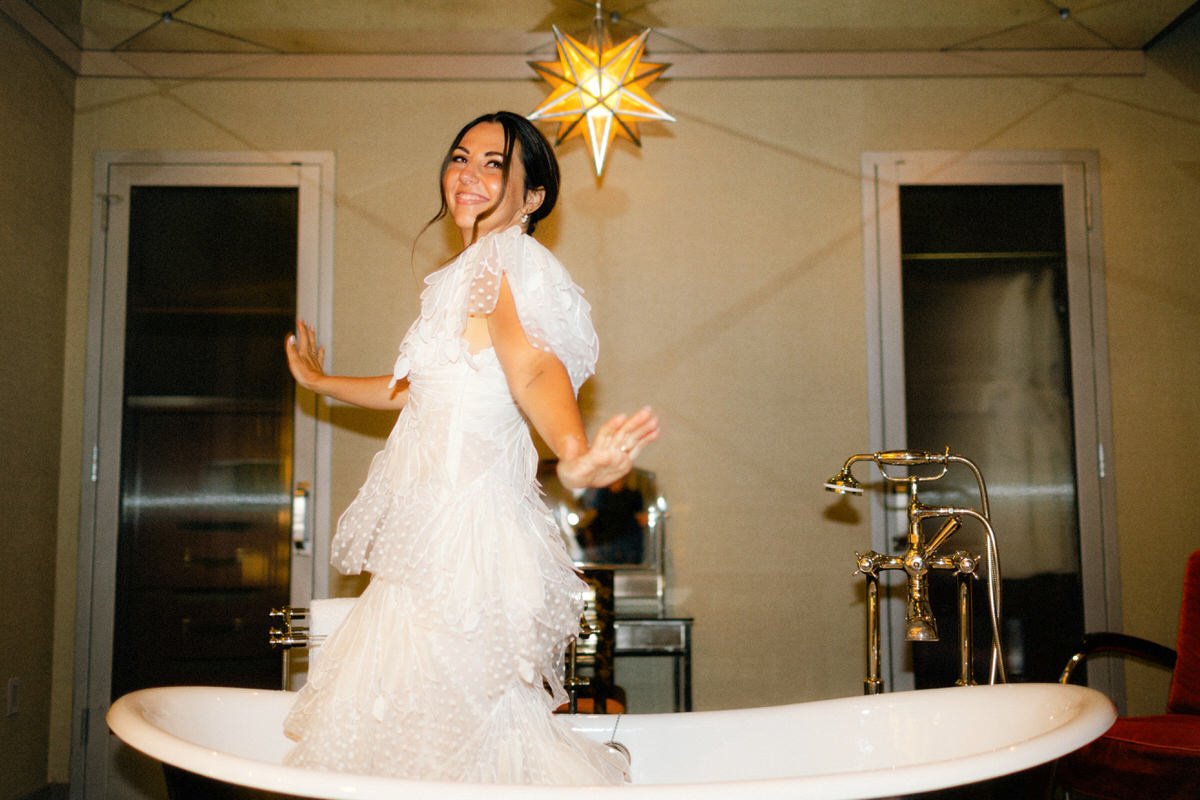 bride wearing Zimmerman dress dancing inside her Grand Soho Hotel room