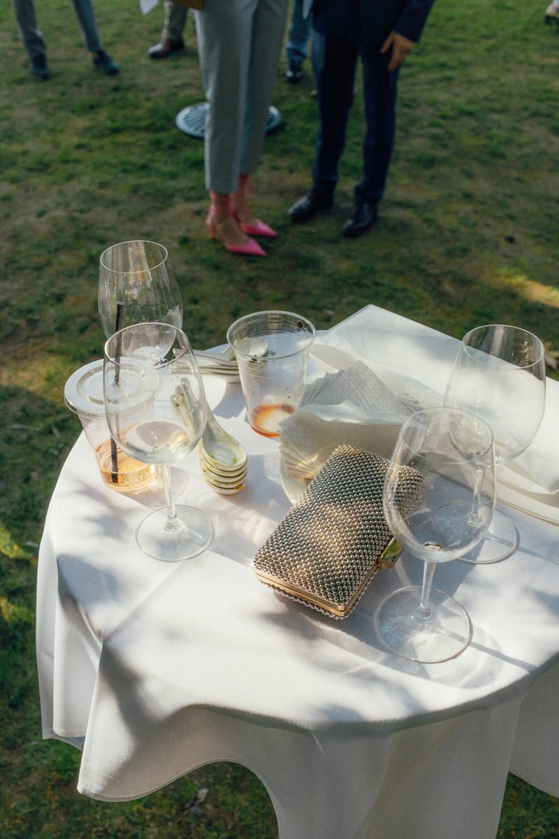 details of empty wine glasses and an ornate pearl clutch at a wedding reception in Vancouver