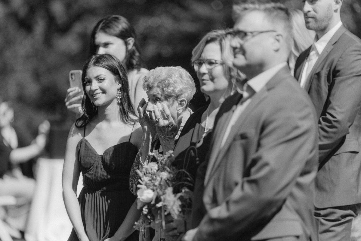 elderly guest wiping away tears during wedding ceremony in Vancouver