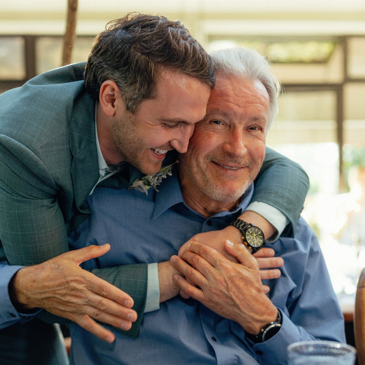 groom hugging happy wedding guest during Vancouver reception