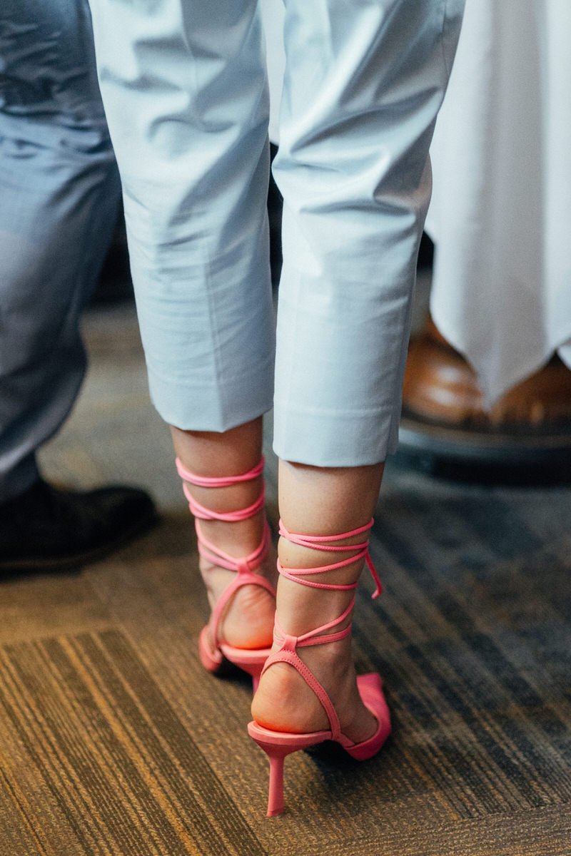 detail photo of wedding guest wearing bright pink strappy heels