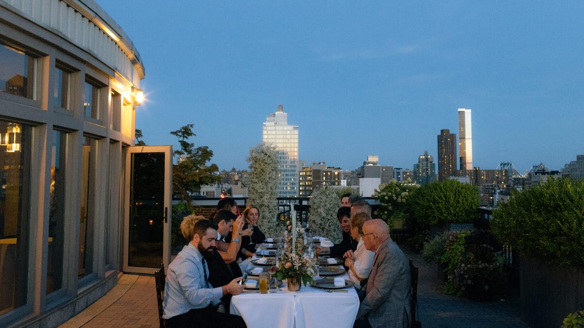 guests enjoying dinner on a Manhattan rooftop serving as an intimate wedding venue