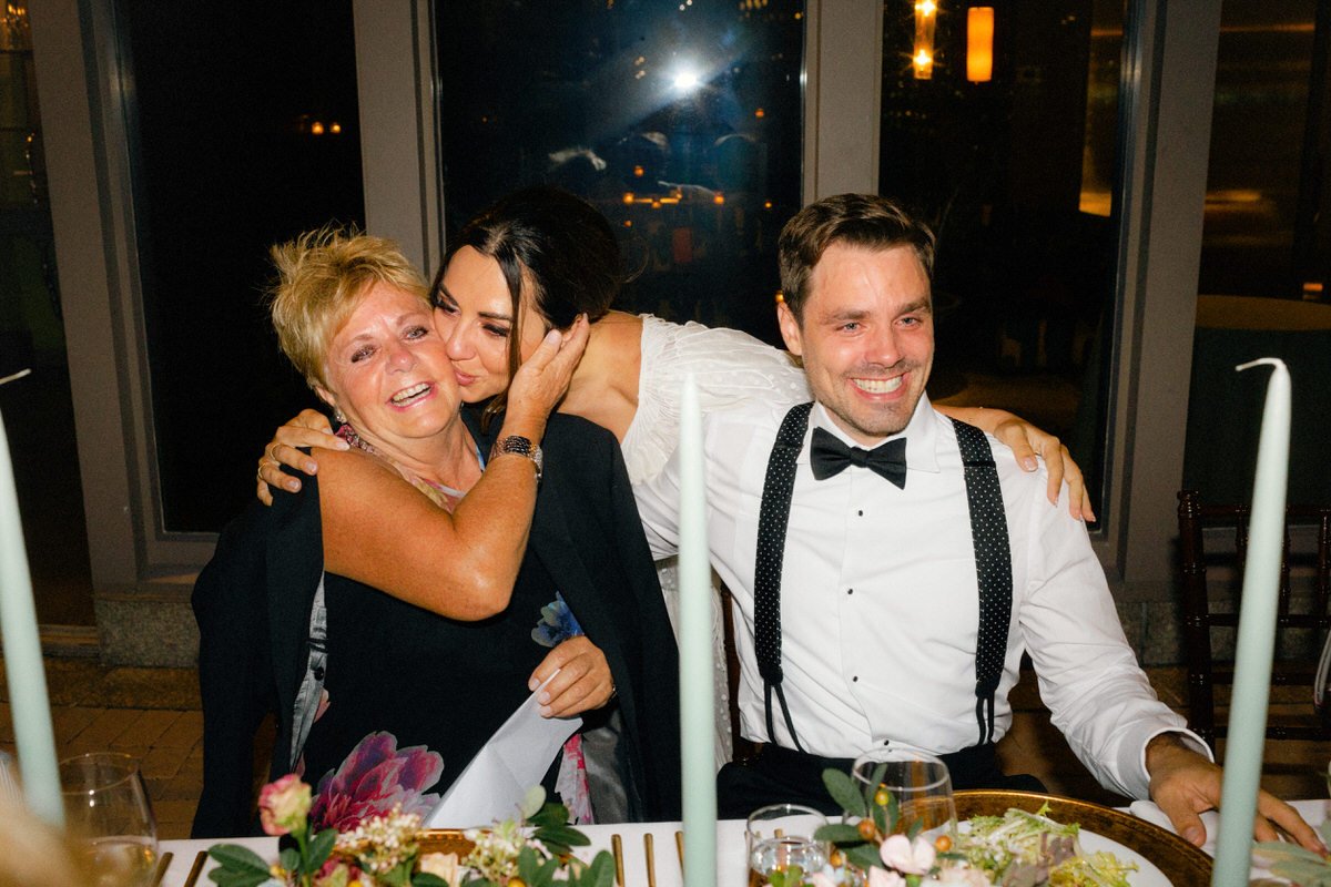 bride kissing her mother in law during a wedding reception in New York