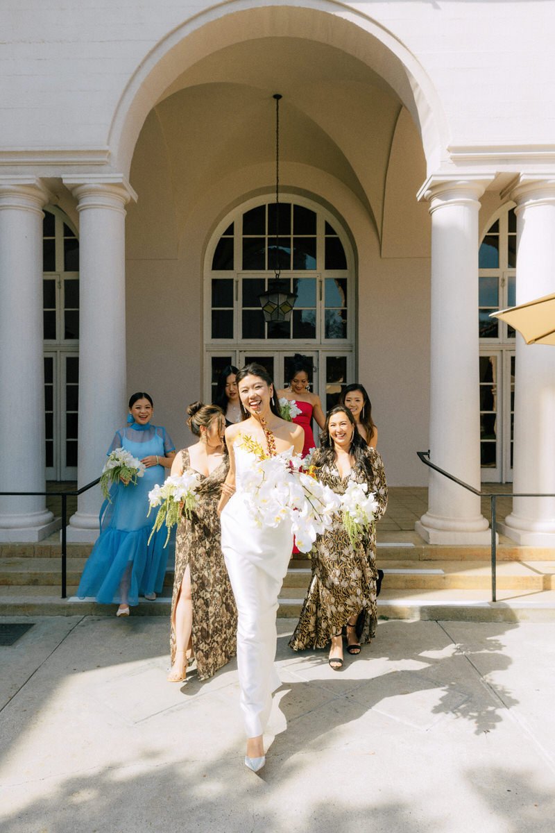 tall bride walking towards the camera as bridesmaids follow