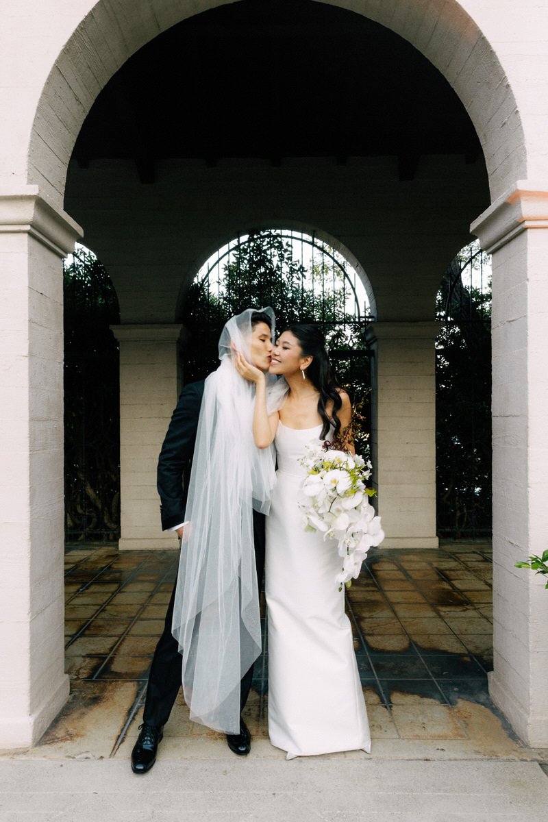 beautiful Korean wedding couple posing under an archway at Ebell of LA