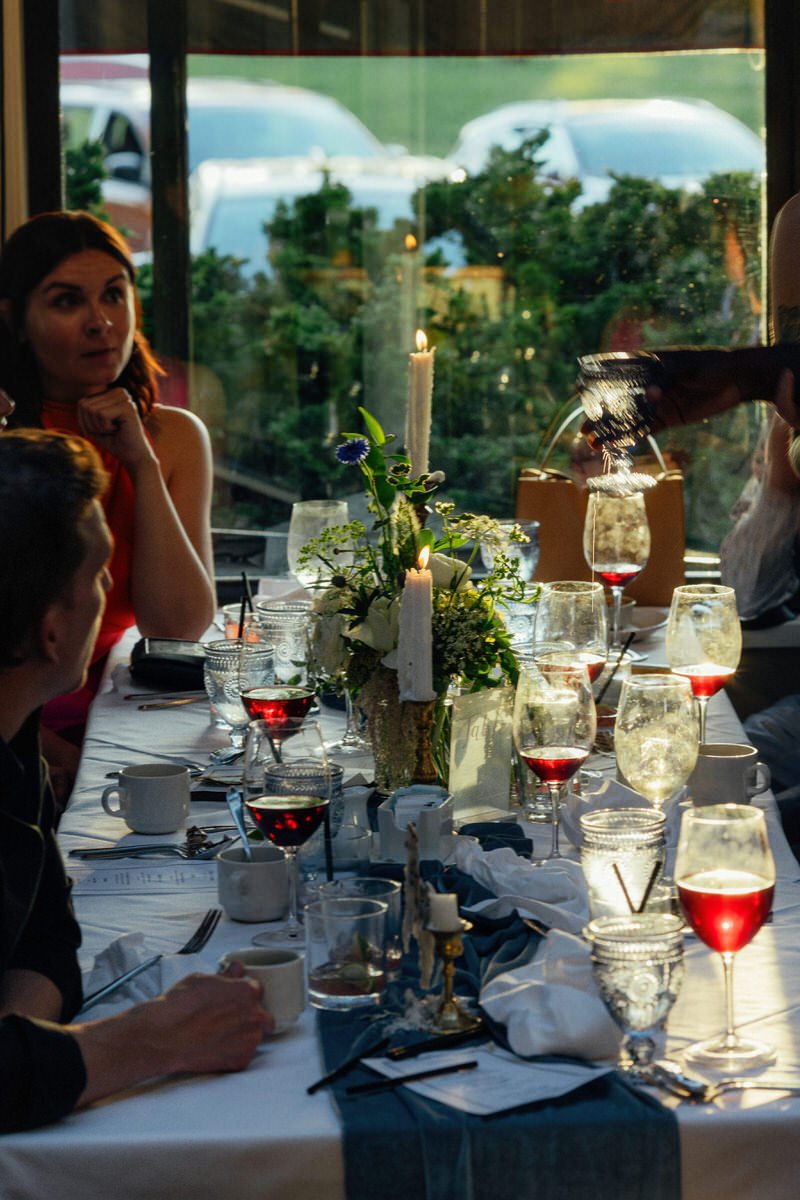 wedding guests being served red wine at Teahouse in Stanley Park