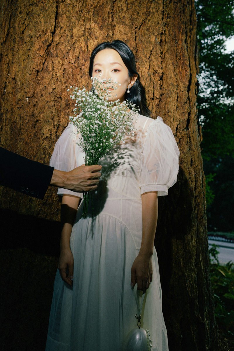 groom holding babys breath bouquet in front of brides face