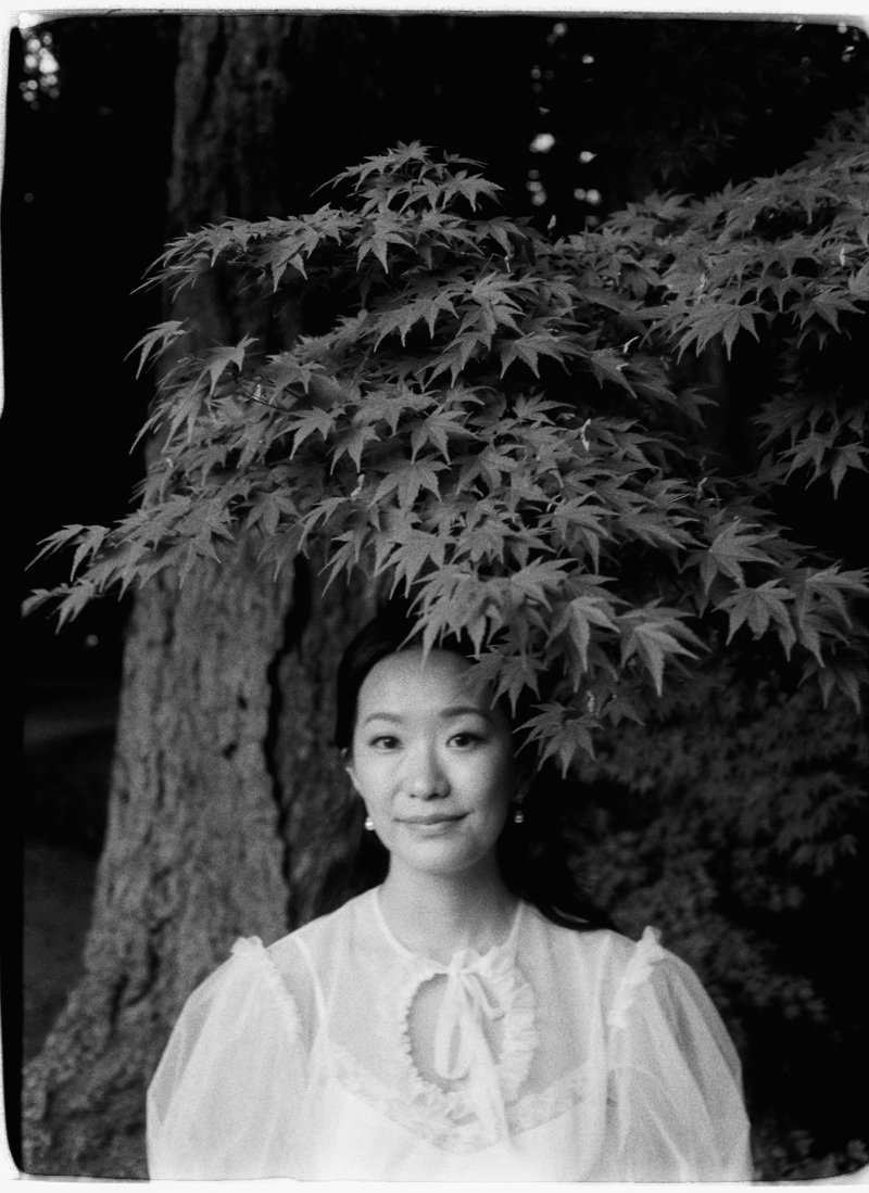 35mm photo of a woman standing under a maple tree branch