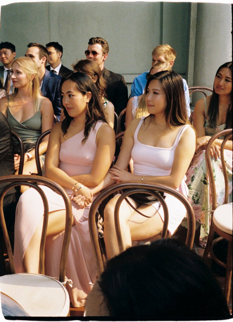 35mm photo of guests holding hands during wedding ceremony