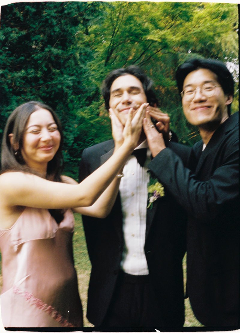 playful 35mm photo of wedding guests with the groom during cocktail hour