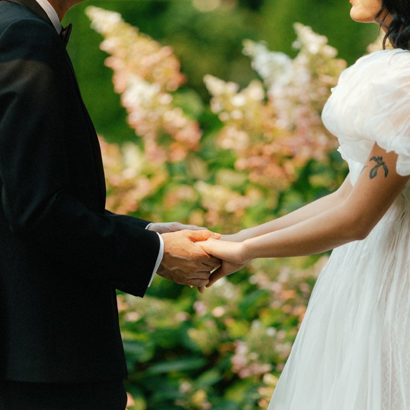 detail shot of groom and bride holding hands