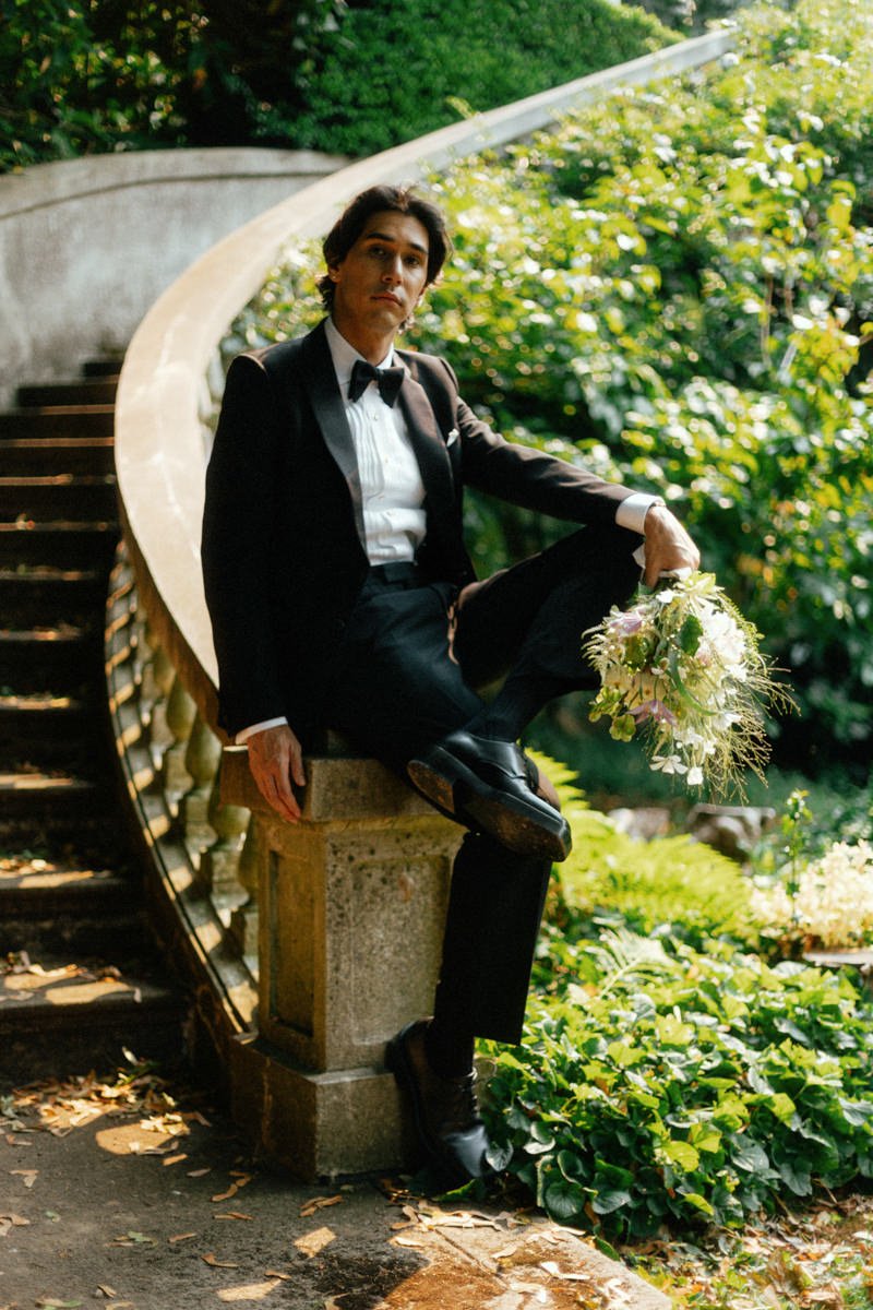 portrait of groom holding bouquet