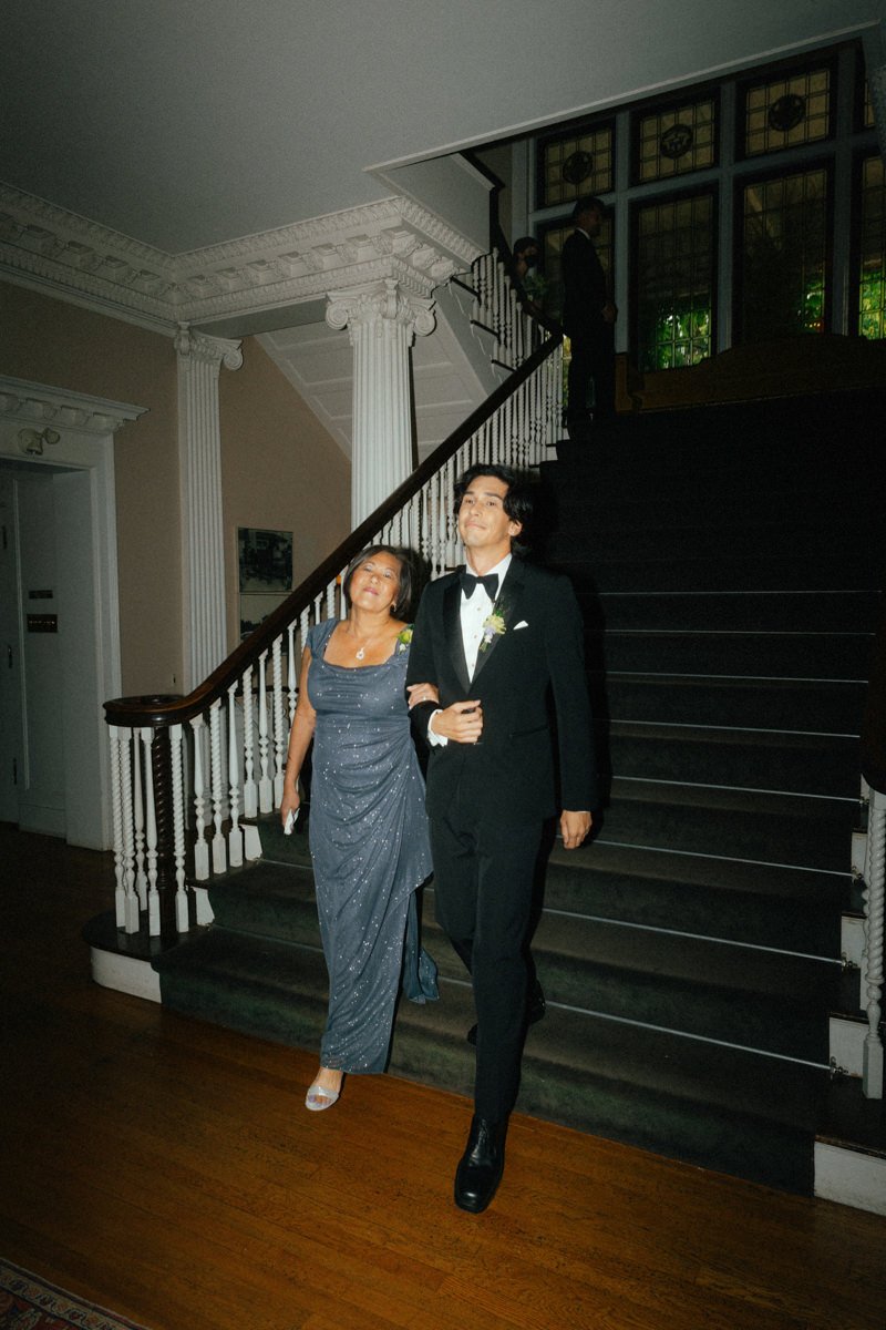groom and his mother walking into the wedding ceremony