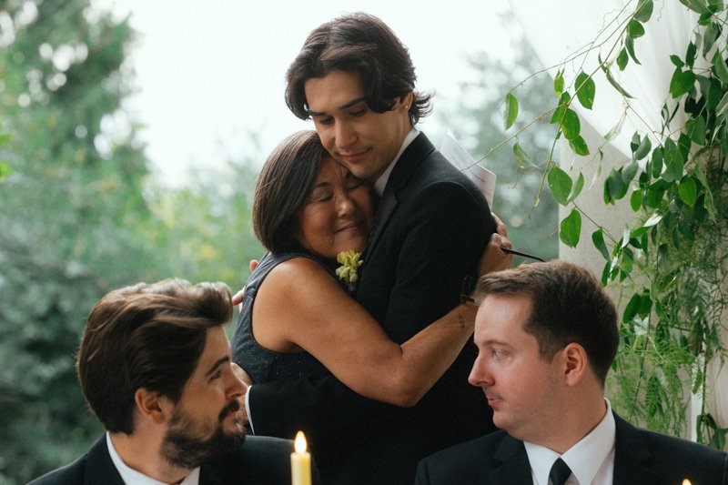 grooms mom embracing son during wedding repcetion