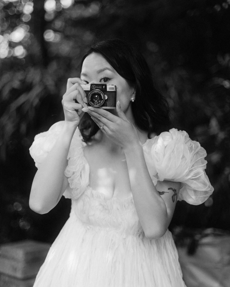 groom holding olympus pen d film camera