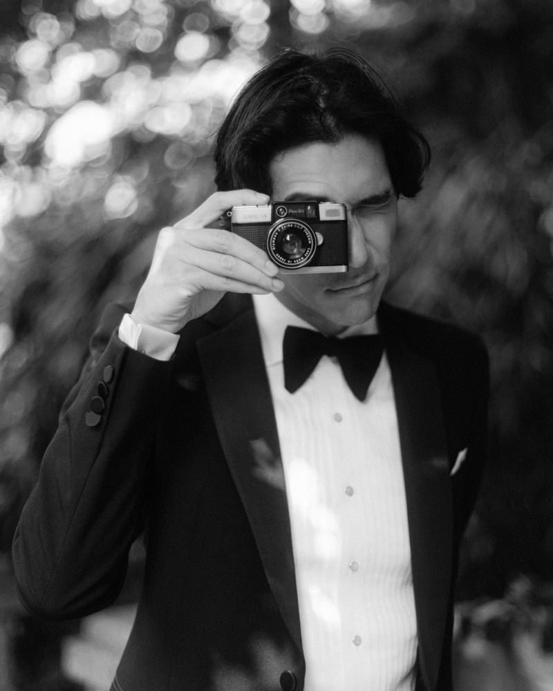 groom holding olympus pen d film camera