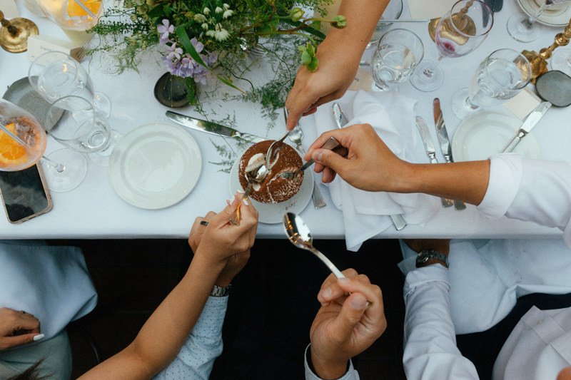 multiple wedding guests eating one tiramisu dessert