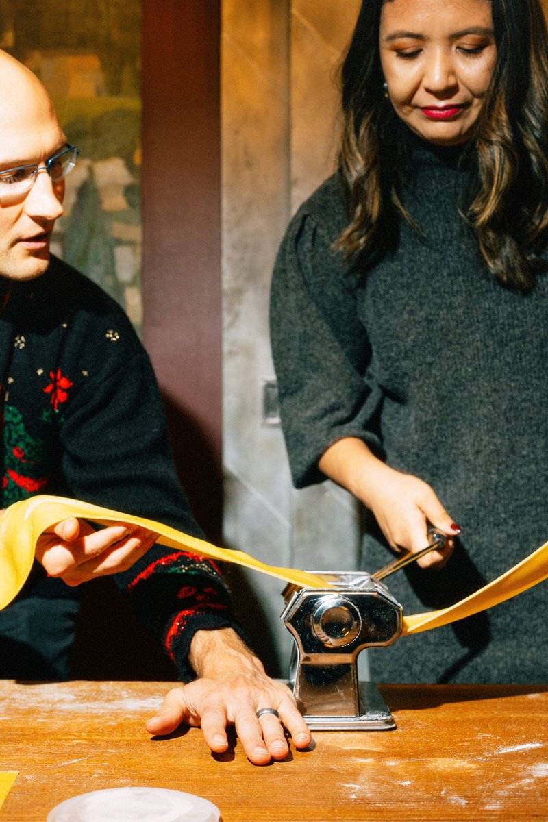 great welcome event idea for out of town guests. two people are making fresh pasta