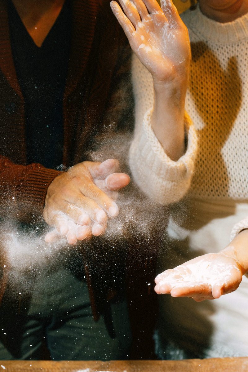 bride and groom clapping white flour for dramatic effect during a pasta making class in Seattle