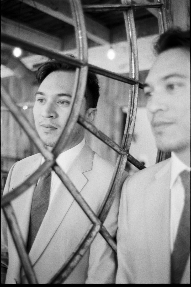 35mmm film photo of groom reflected in an abstract mirror hanging inside Withinsodo Seattle