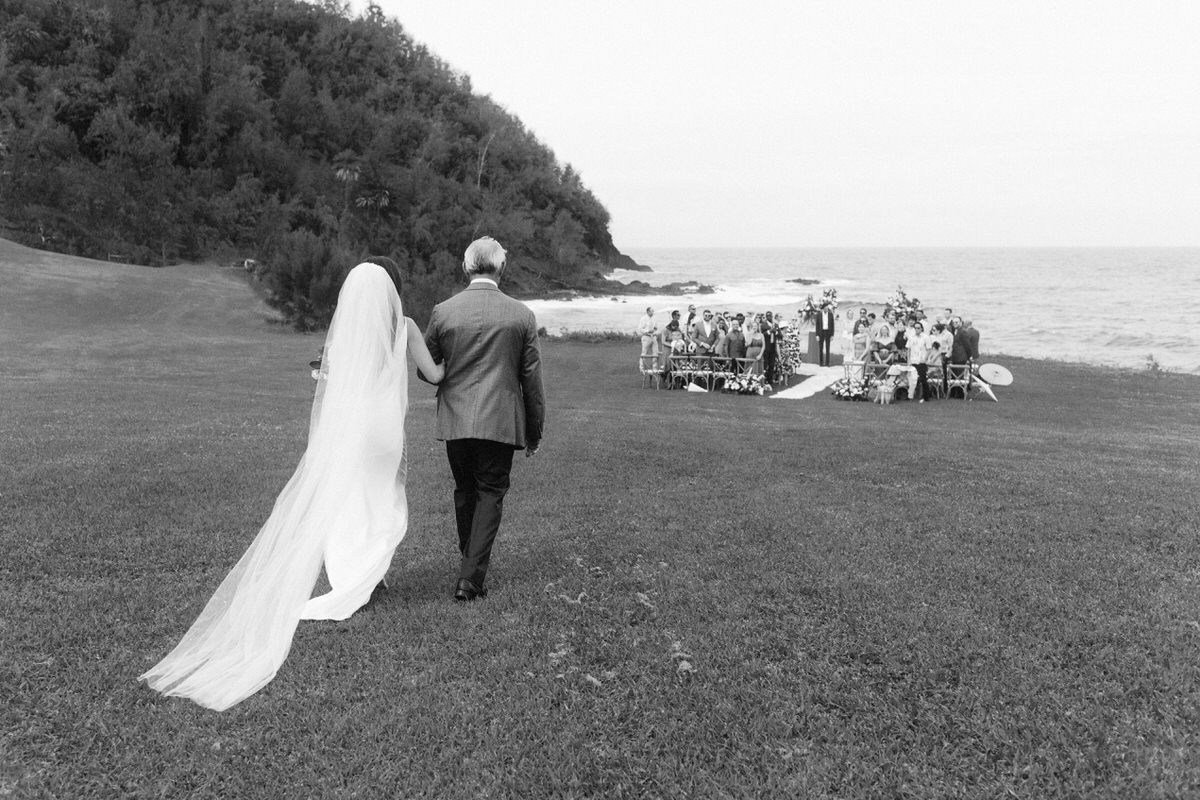 bride walking towards wedding ceremony overlooking a beautiful view of Maui