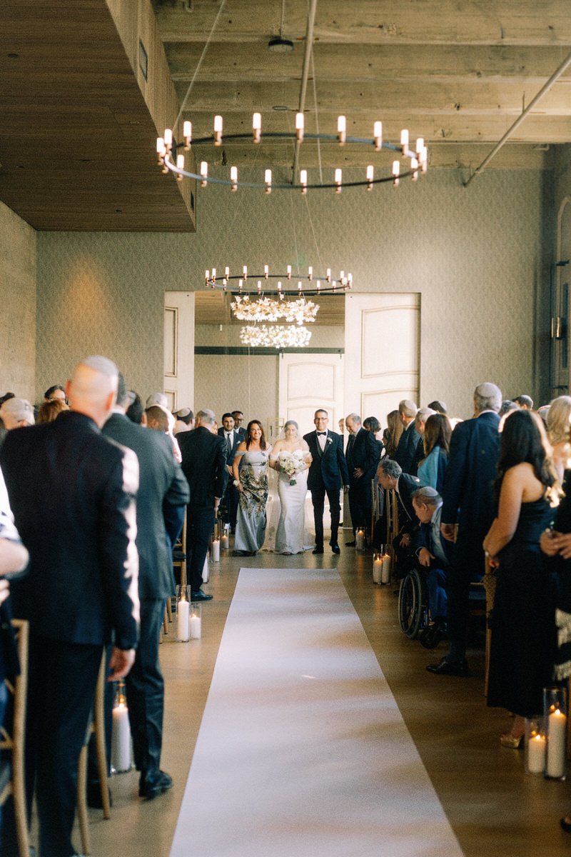 bride walking up the aisle with her parents at the Switch House by Cescaphe