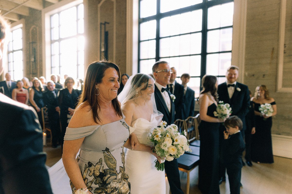 bride smiling with her parents during the wedding ceremony at the Switch House by Cescaphe