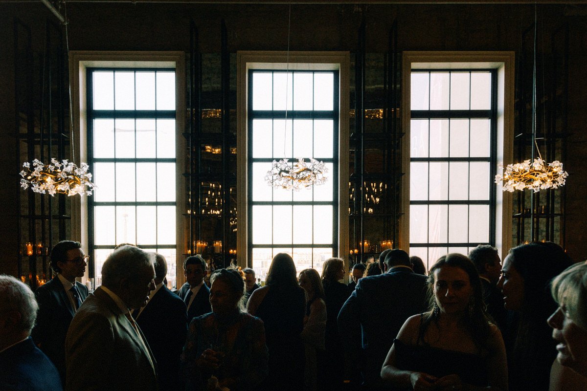 guests during the cocktail reception at the Switch House by Cescaphe. they are lit by natural window light and sculptural hanging lamps