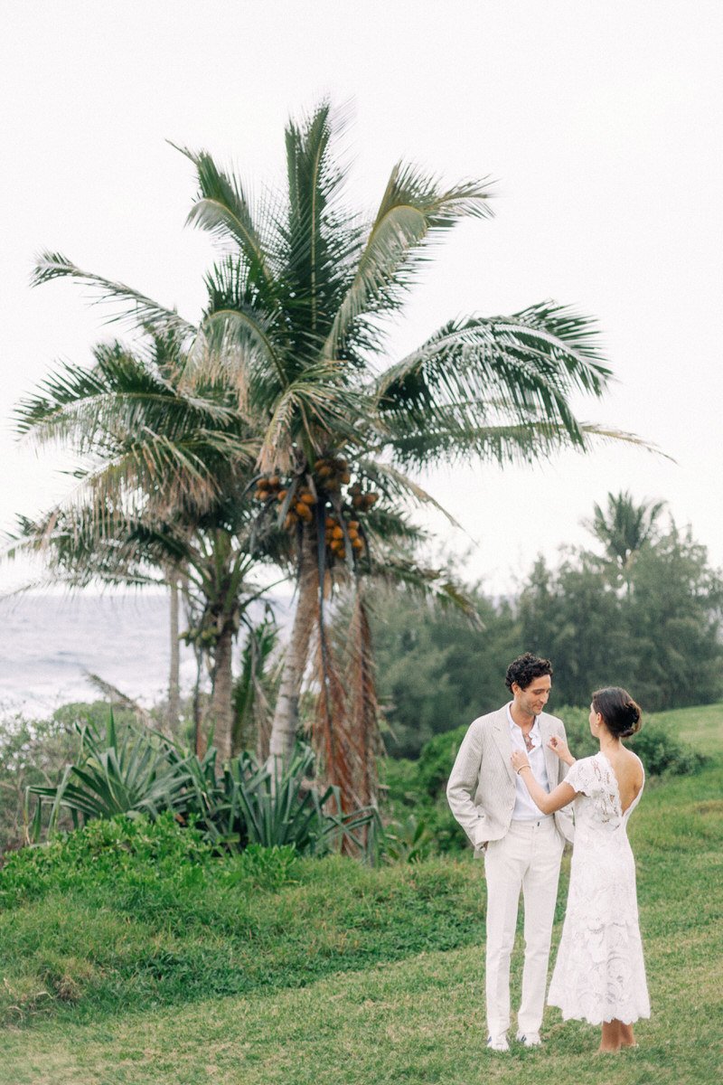 engaged couple posing beside a palm tree in Maui