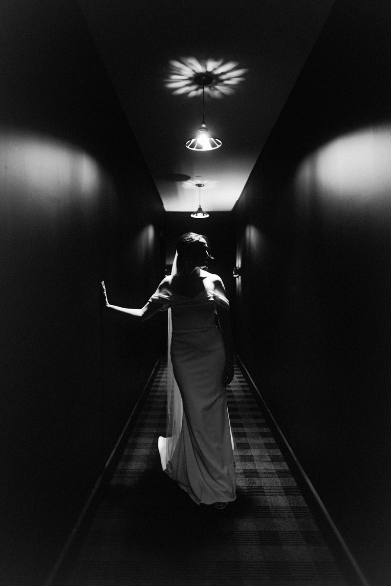 dramatic scene of bride standing in a dimly lit hallway inside the Switch House by Cescaphe