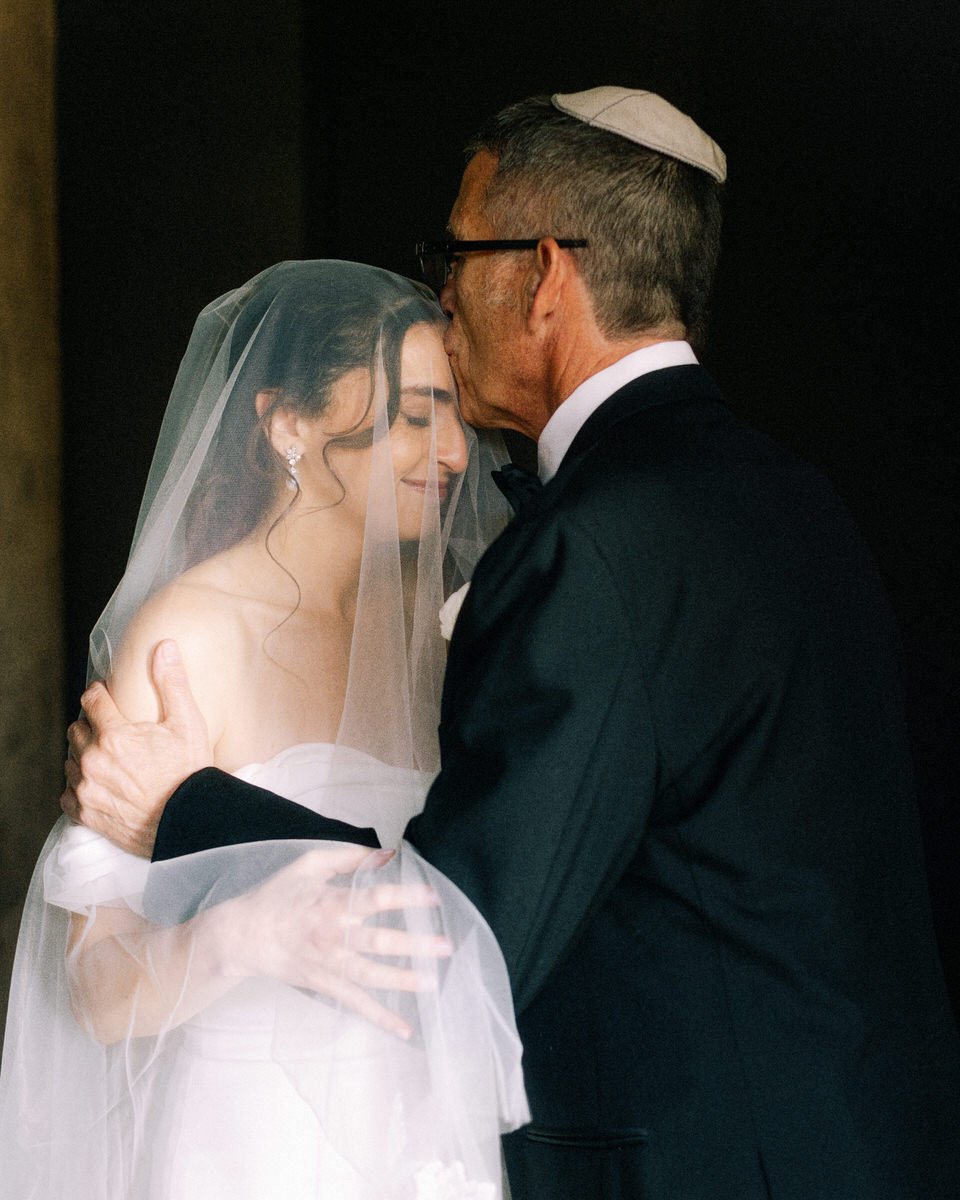 Jewish father kissing the bride on her forehead ahead of the ceremony at the Switch House by Cescaphe