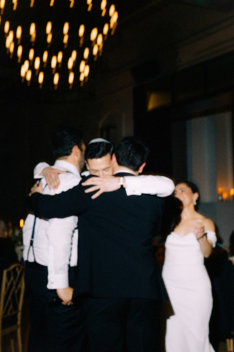 Jewish groom hugging his brothers during a reception dinner in Philadelphia