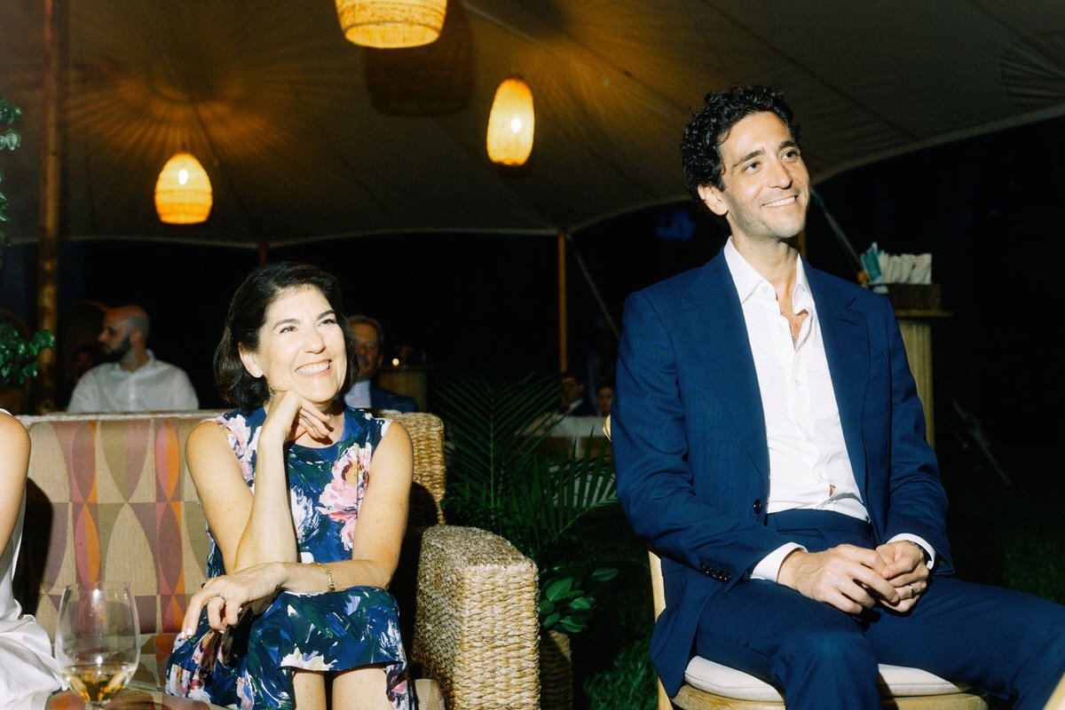groom and mother smiling during speeches at his wedding in Hawaii