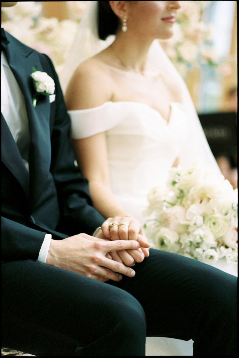 wedding couple holding hands during their ceremony at the AGO captured on 35mm film