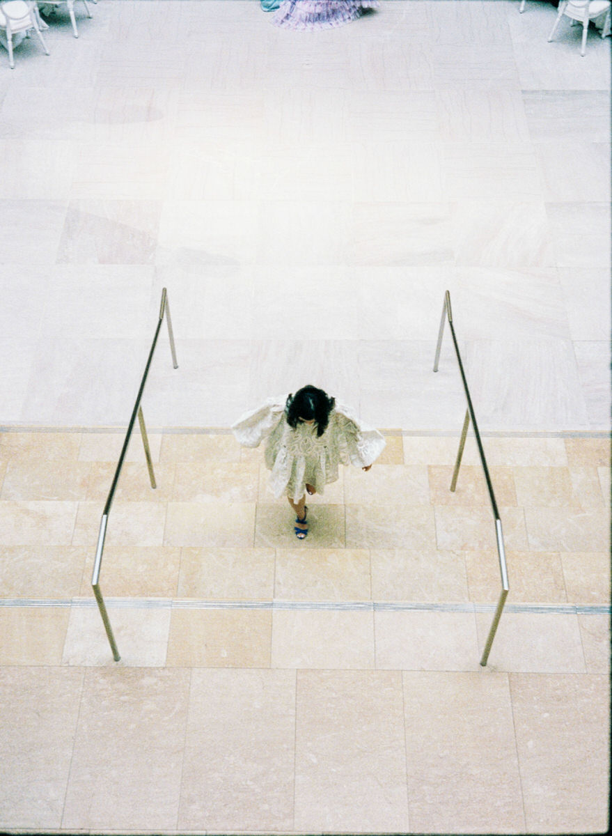 wedding guest perfectly framed by stair railings inside the AGO Walker Court